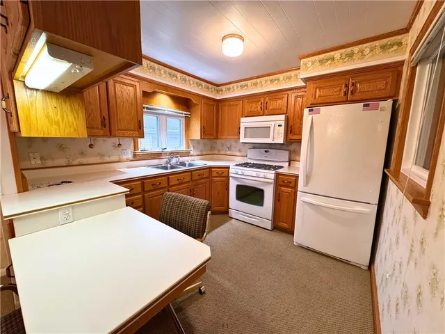 a kitchen with stainless steel appliances granite countertop a refrigerator a stove a sink and white cabinets with wooden floor