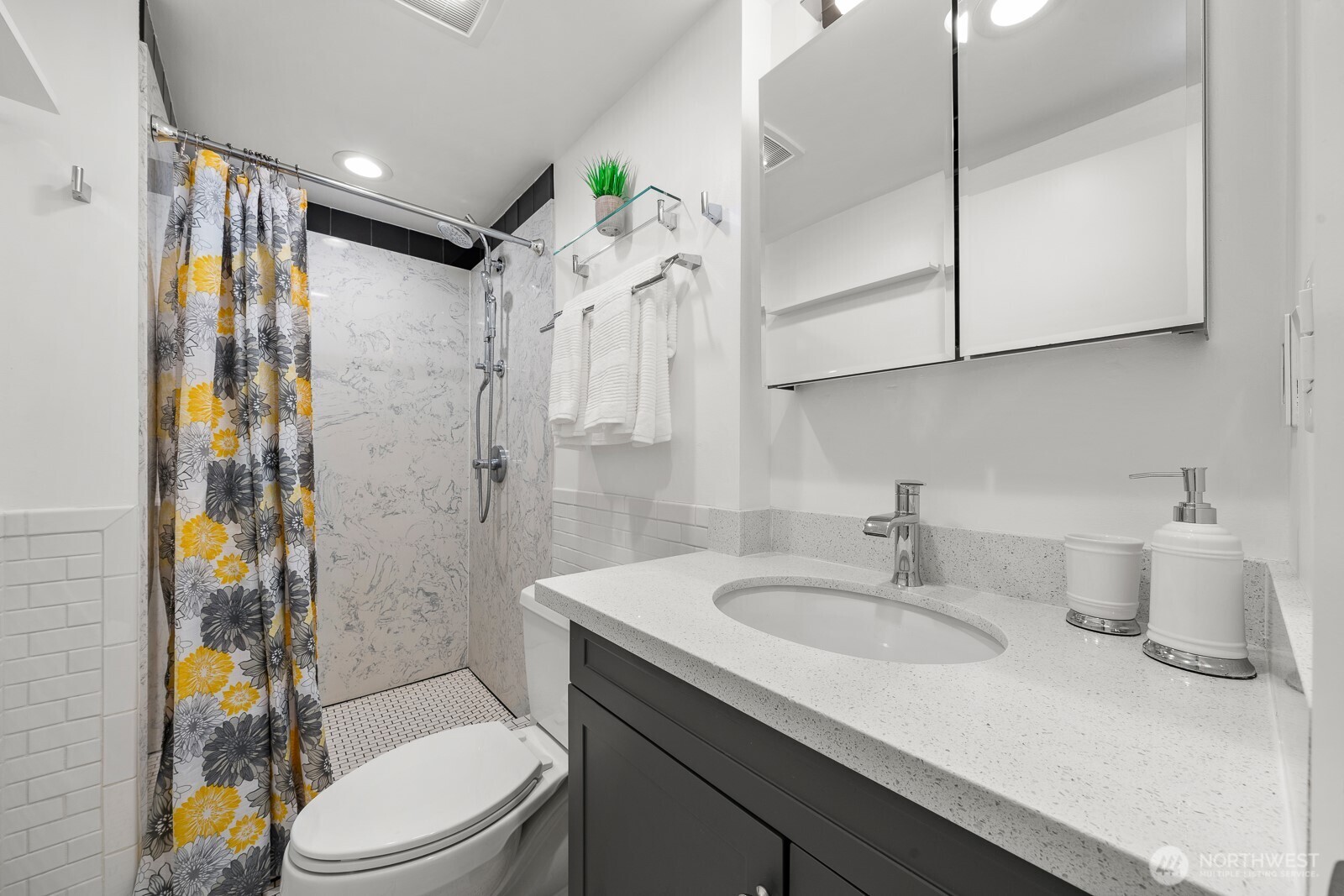 912 3rd Avenue West, Unit 101 Seattle, WA 98119 - Photo 19 of 25 a bathroom with a sink toilet tub and shower