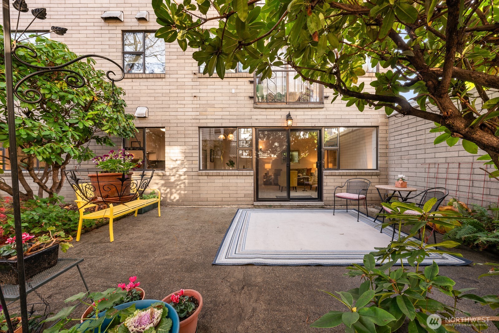 912 3rd Avenue West, Unit 101 Seattle, WA 98119 - Photo 2 of 25 a view of a patio with table and chairs and potted plants