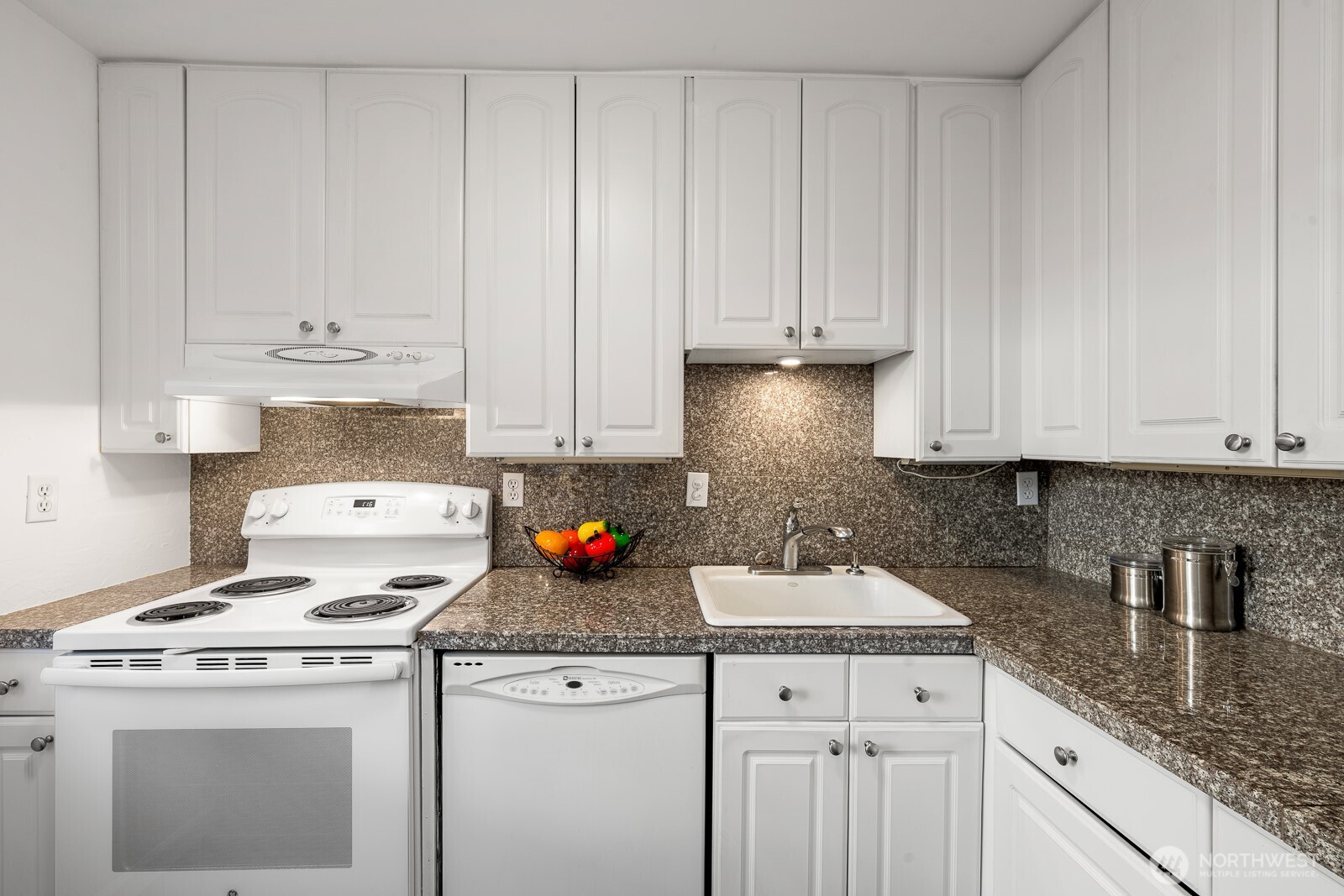 912 3rd Avenue West, Unit 101 Seattle, WA 98119 - Photo 8 of 25 a kitchen with granite countertop white cabinets and white appliances