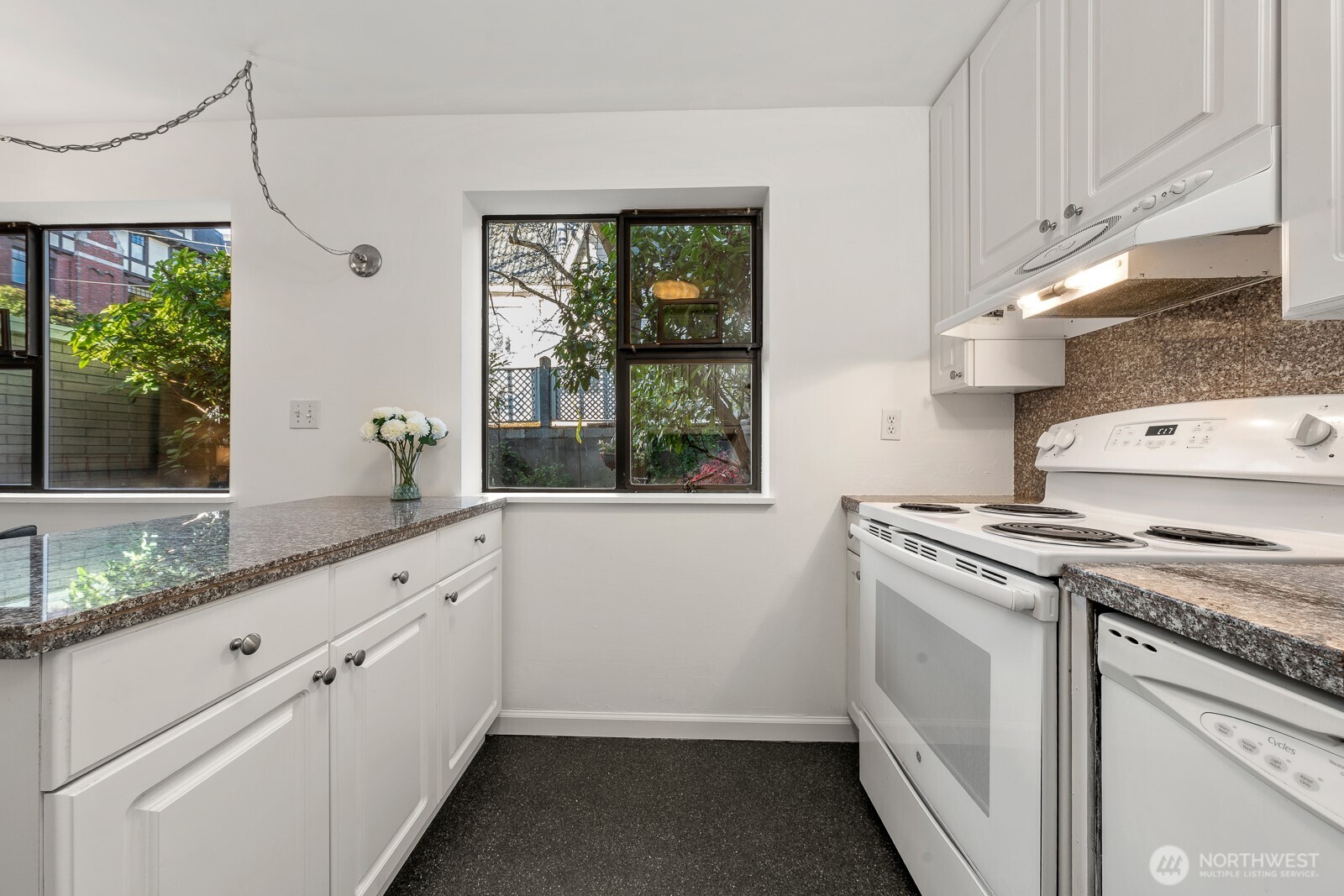 912 3rd Avenue West, Unit 101 Seattle, WA 98119 - Photo 9 of 25 a kitchen with granite countertop white cabinets and a stove