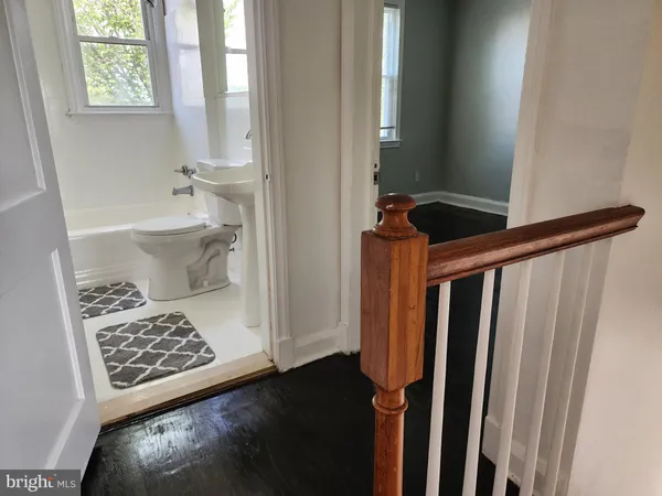 a view of a hallway with wooden floor and a carpet