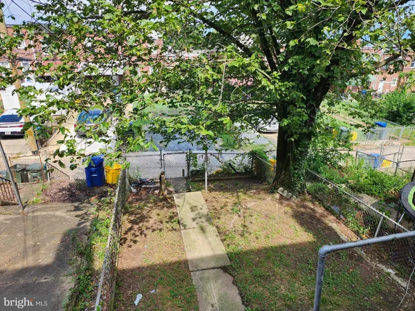 a front view of a building with yard swimming pool and trees in the background