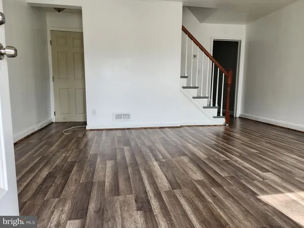 a view of hallway with wooden floor and stairs