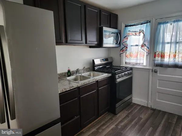 a kitchen with stainless steel appliances granite countertop a sink stove and microwave