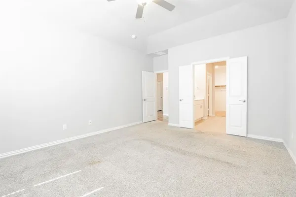 an empty room with chandelier fan