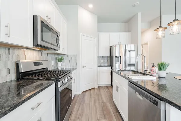 a kitchen with stainless steel appliances granite countertop a sink stove and refrigerator