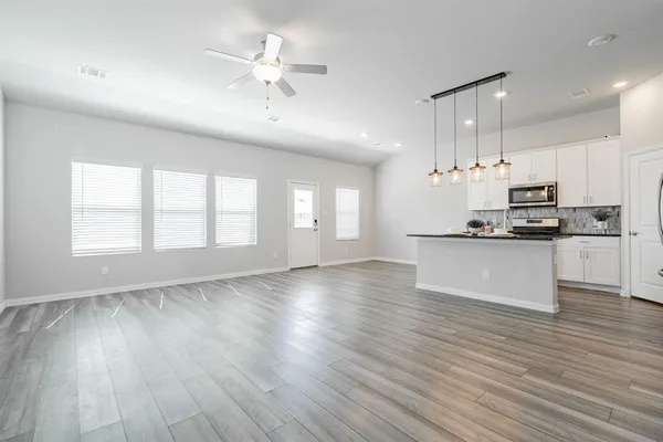a view of kitchen with sink microwave and cabinets
