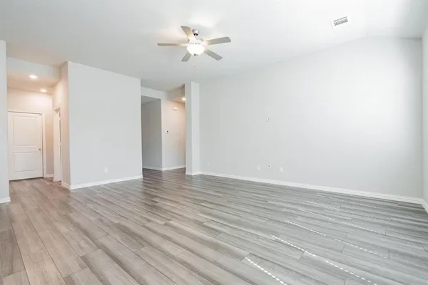 a view of an empty room with wooden floor