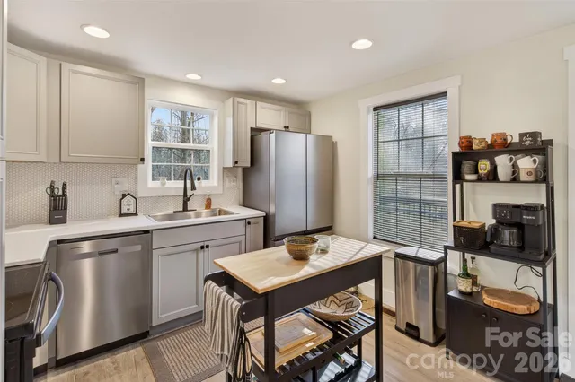 a kitchen with stainless steel appliances granite countertop a refrigerator and a stove top oven