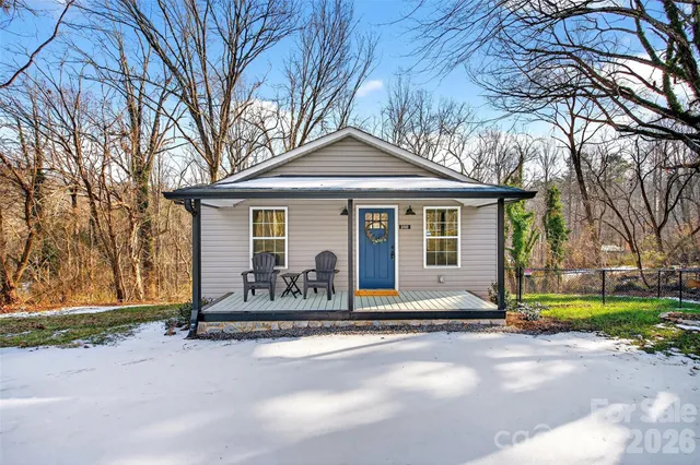 a front view of a house with a garden and trees
