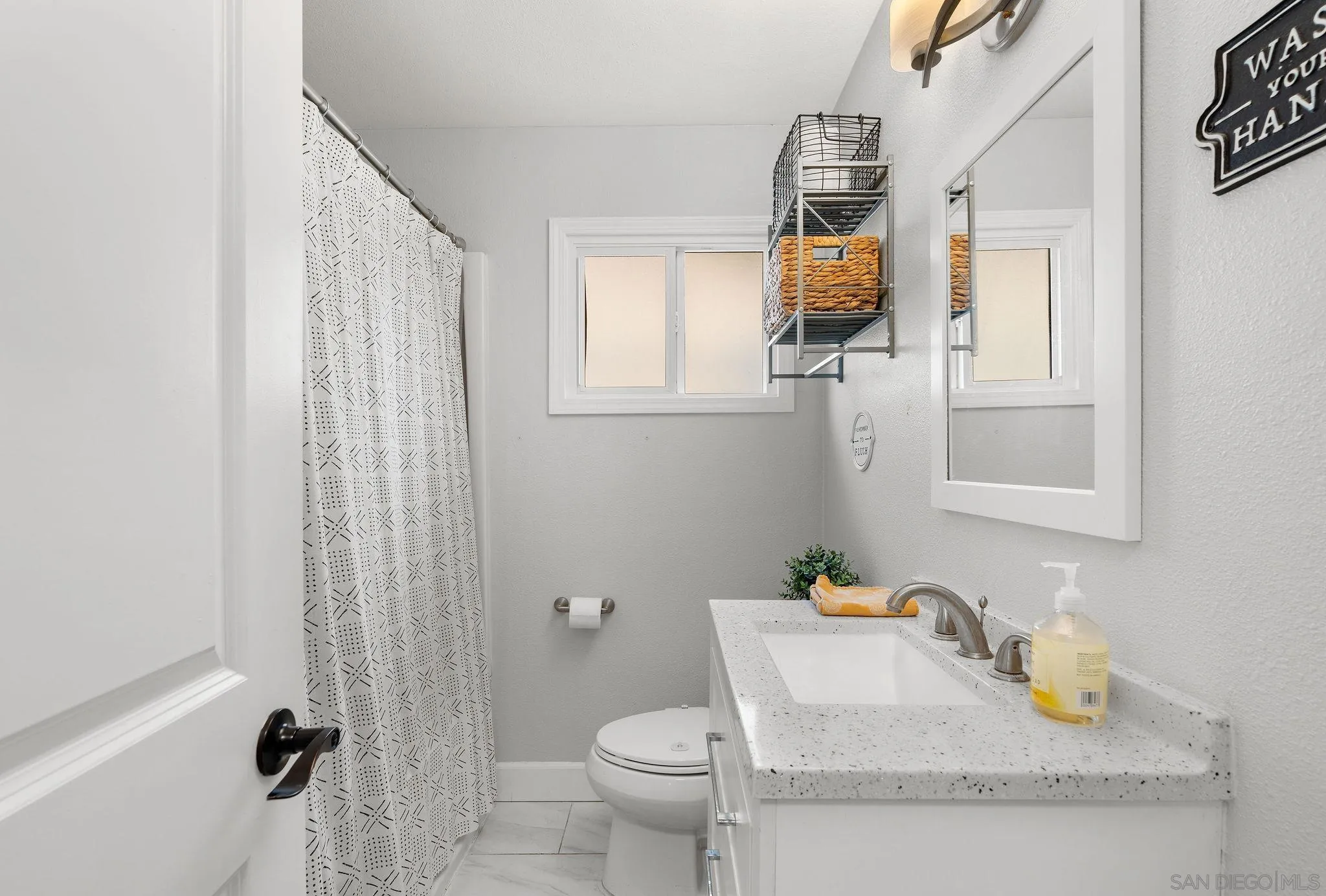 9735 Vomac Road Santee, CA 92071 - Photo 14 of 40 a bathroom with a granite countertop sink a toilet and mirror