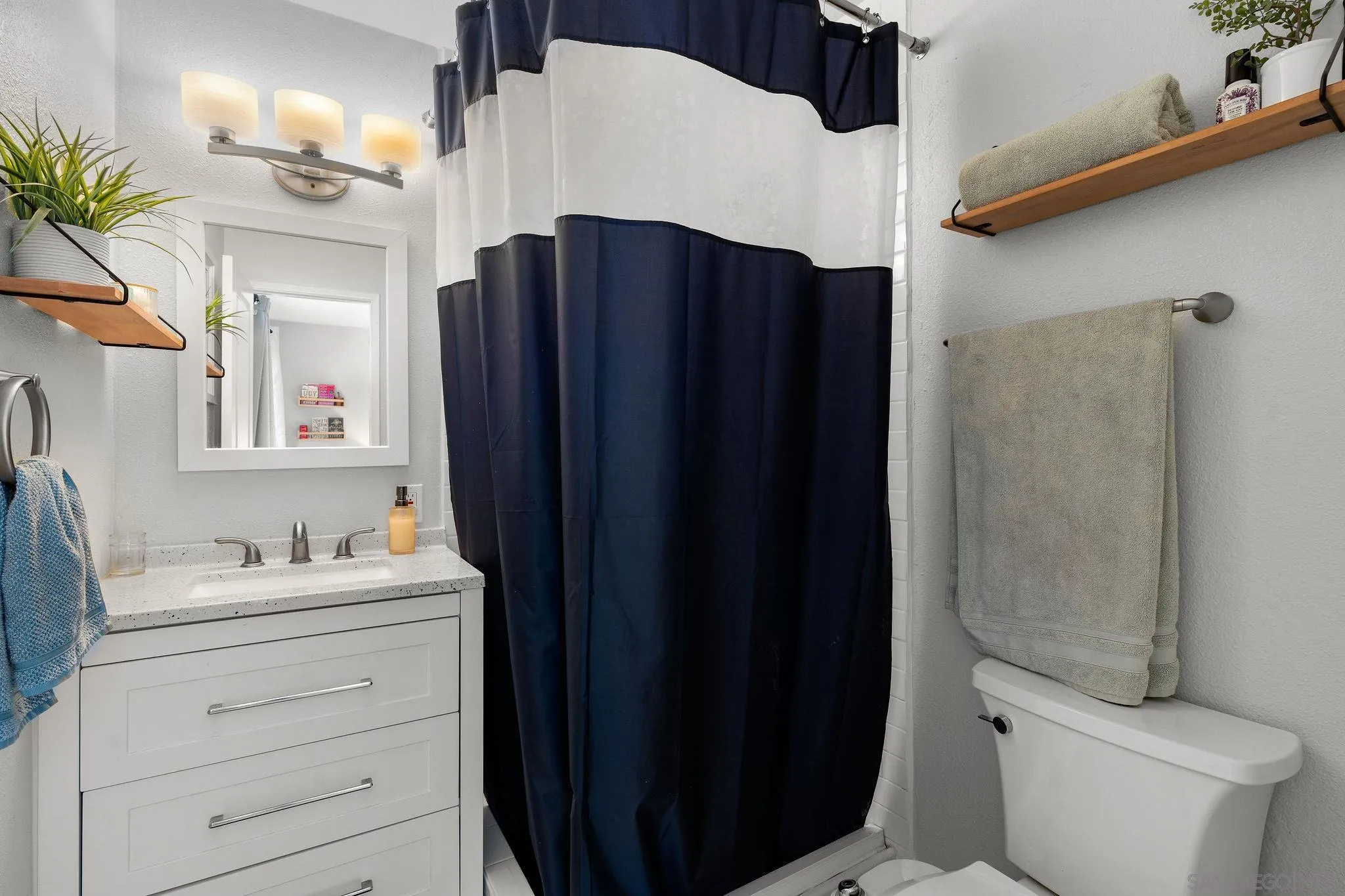 9735 Vomac Road Santee, CA 92071 - Photo 17 of 40 a bathroom with a sink vanity toilet and shower