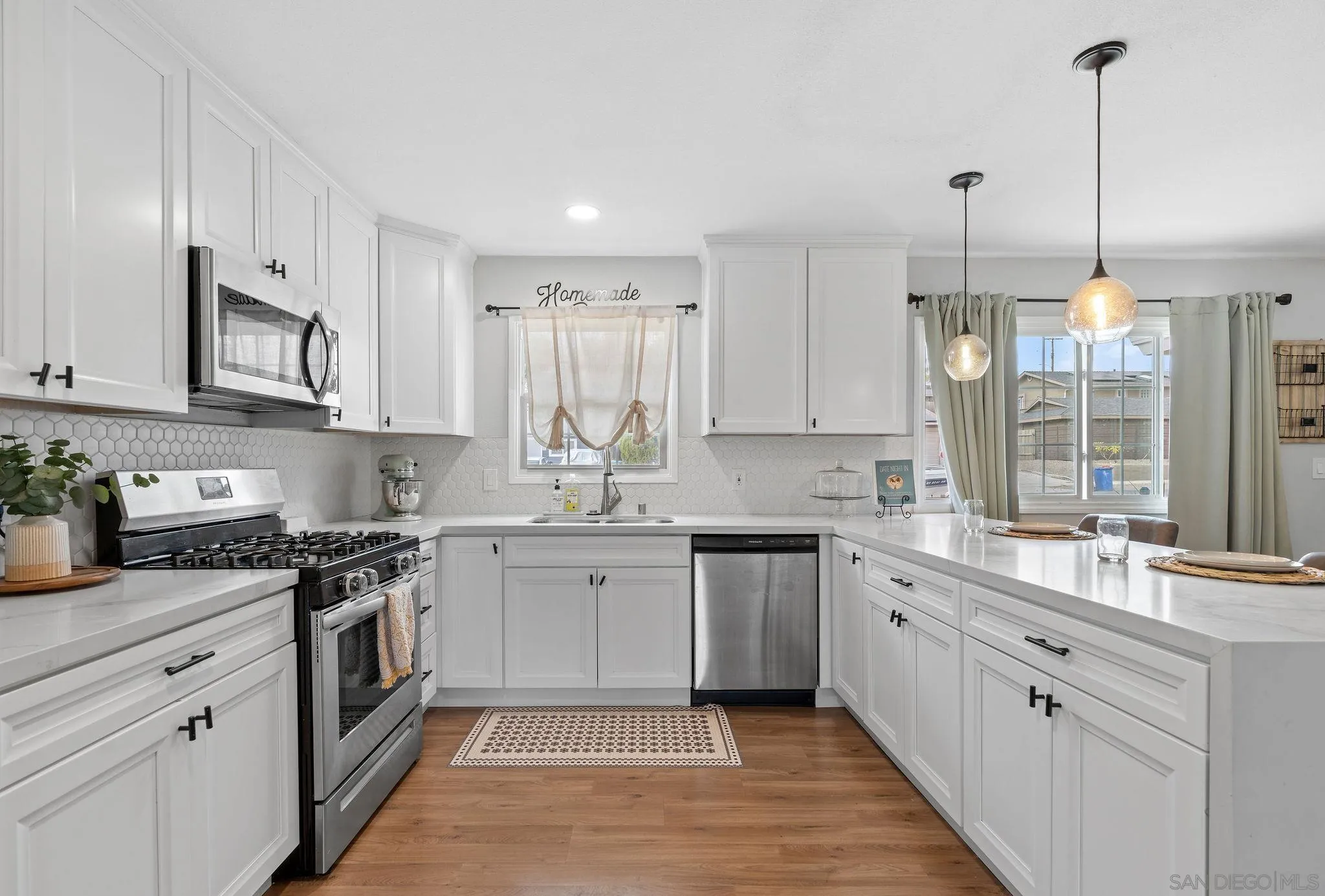 9735 Vomac Road Santee, CA 92071 - Photo 7 of 40 a kitchen with a sink stove and cabinets