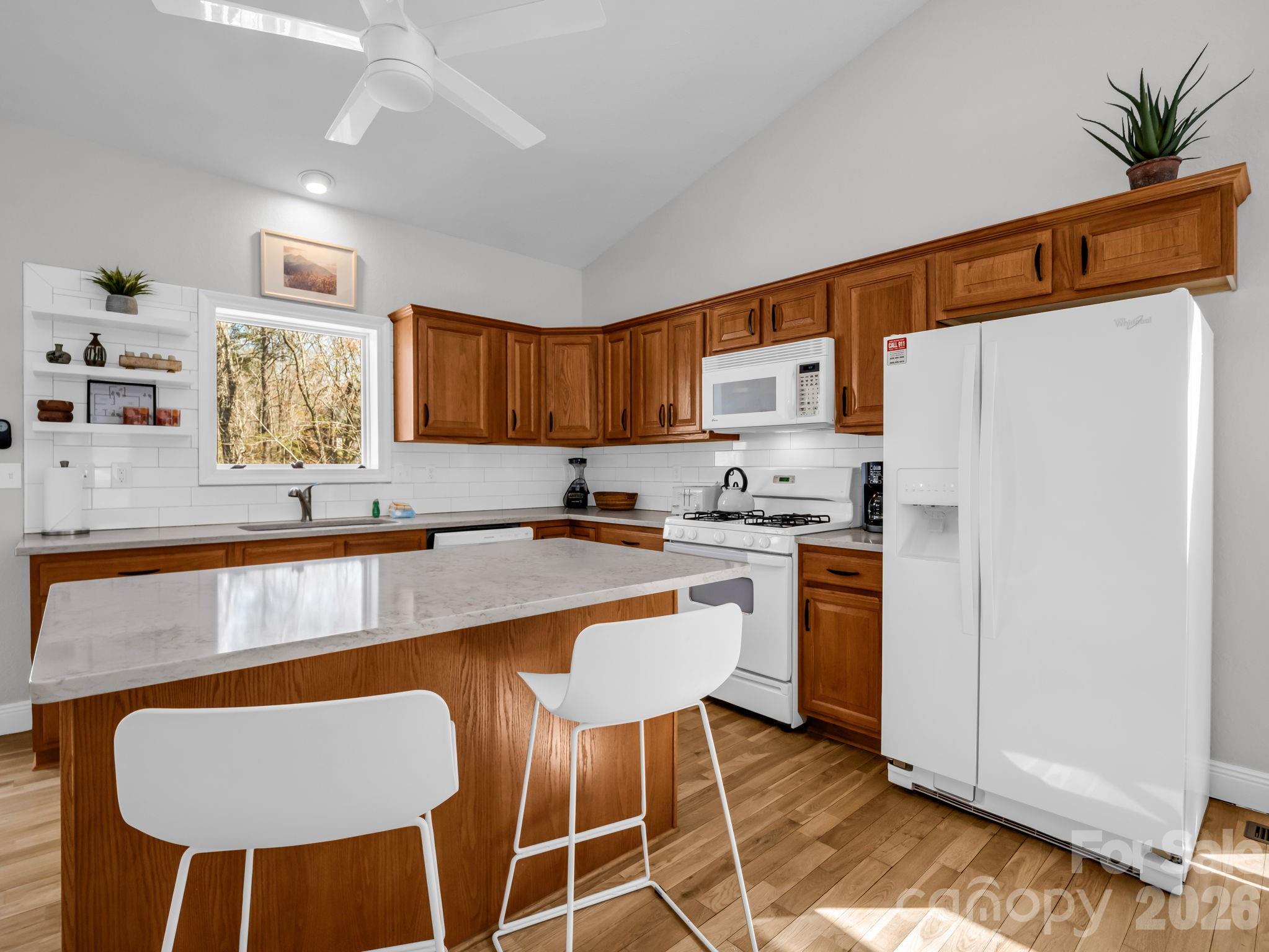 121 Fern Loop Lake Lure, NC 28746 - Photo 27 of 40 a kitchen with stainless steel appliances granite countertop a sink a stove a refrigerator cabinets and chairs