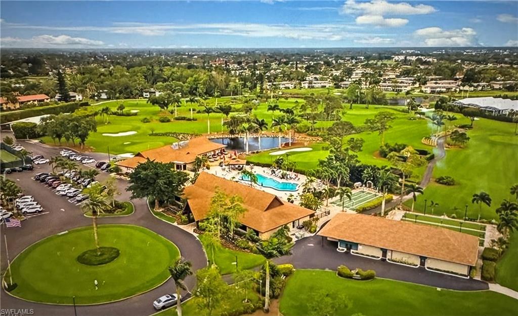 103 Teryl Road, Unit A4 Naples, FL 34112 - Photo 1 of 10 a view of a swimming pool with a table and chairs