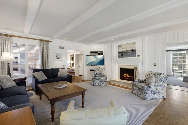 a living room with furniture a fireplace and a floor to ceiling window