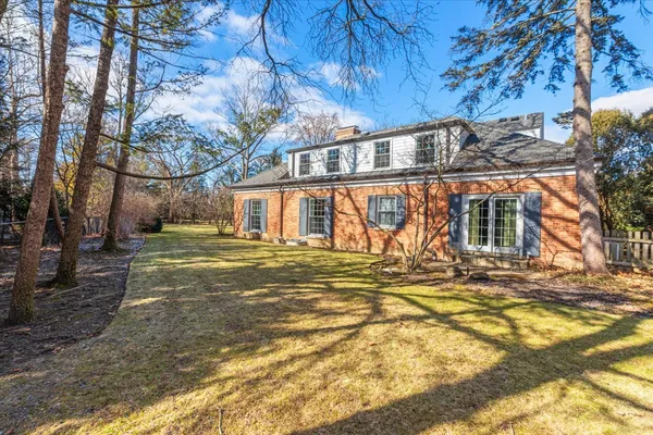 a view of a house with a big yard and large tree