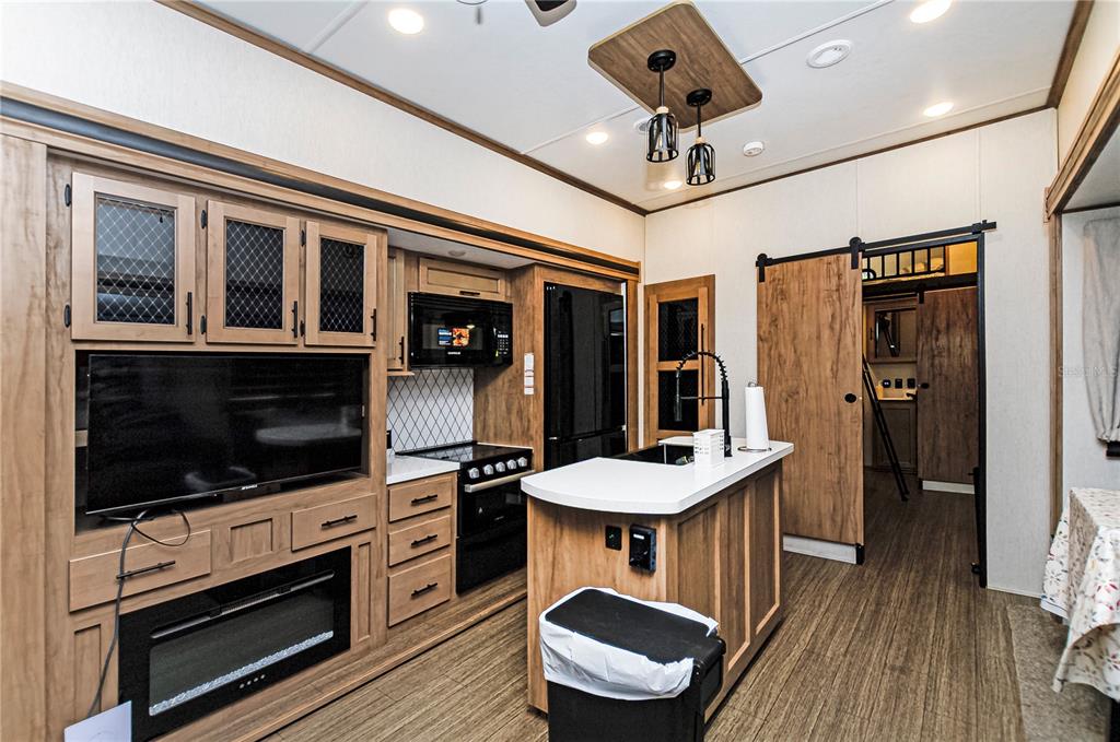 18233 185th Road Live Oak, FL 32060 - Photo 24 of 99 a kitchen with stainless steel appliances kitchen island granite countertop a stove and a microwave