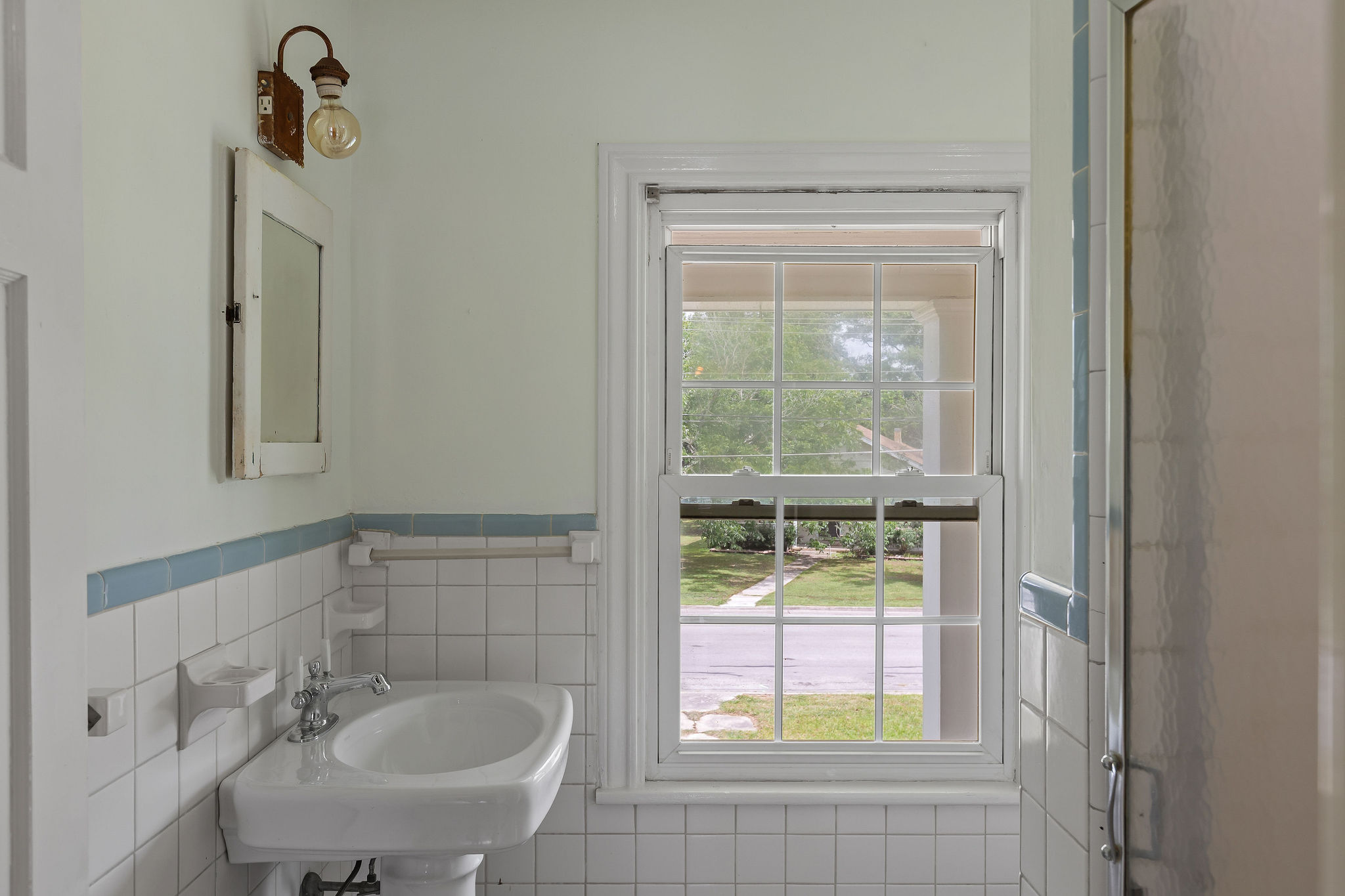 948 Maple Street Lockhart, TX 78644 - Photo 31 of 40 A well-lit bathroom features classic white tile and a functional window.