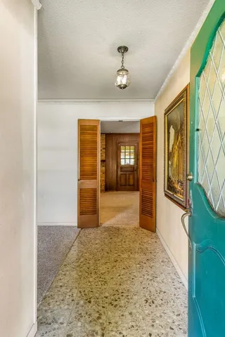a view of an empty room with closet and wooden floor