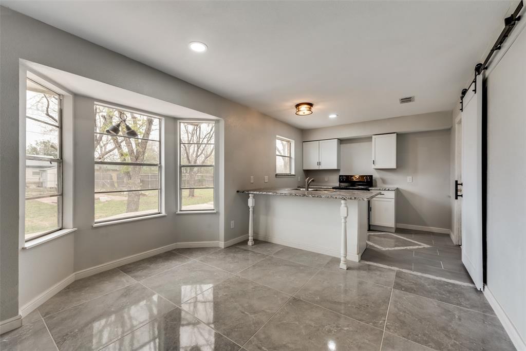 a kitchen with a refrigerator and white cabinets