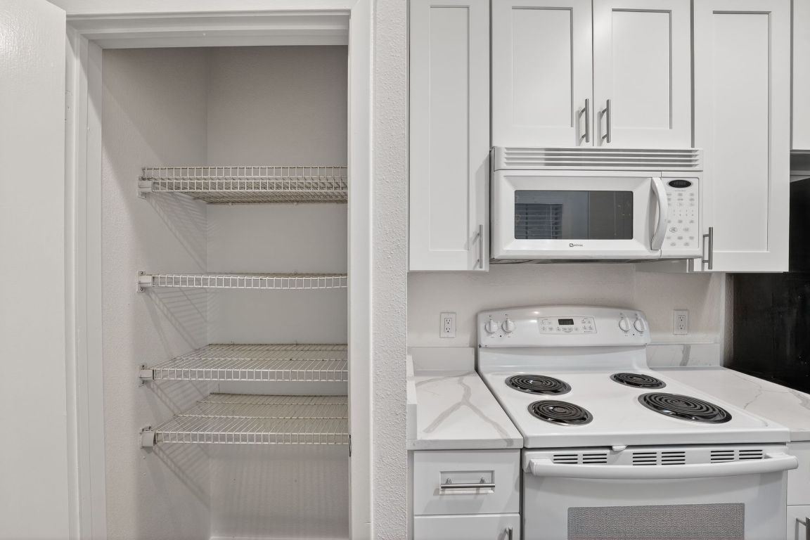 712 Graham Place, Unit 201 Austin, TX 78705 - Photo 11 of 36 a kitchen with a stove and a microwave