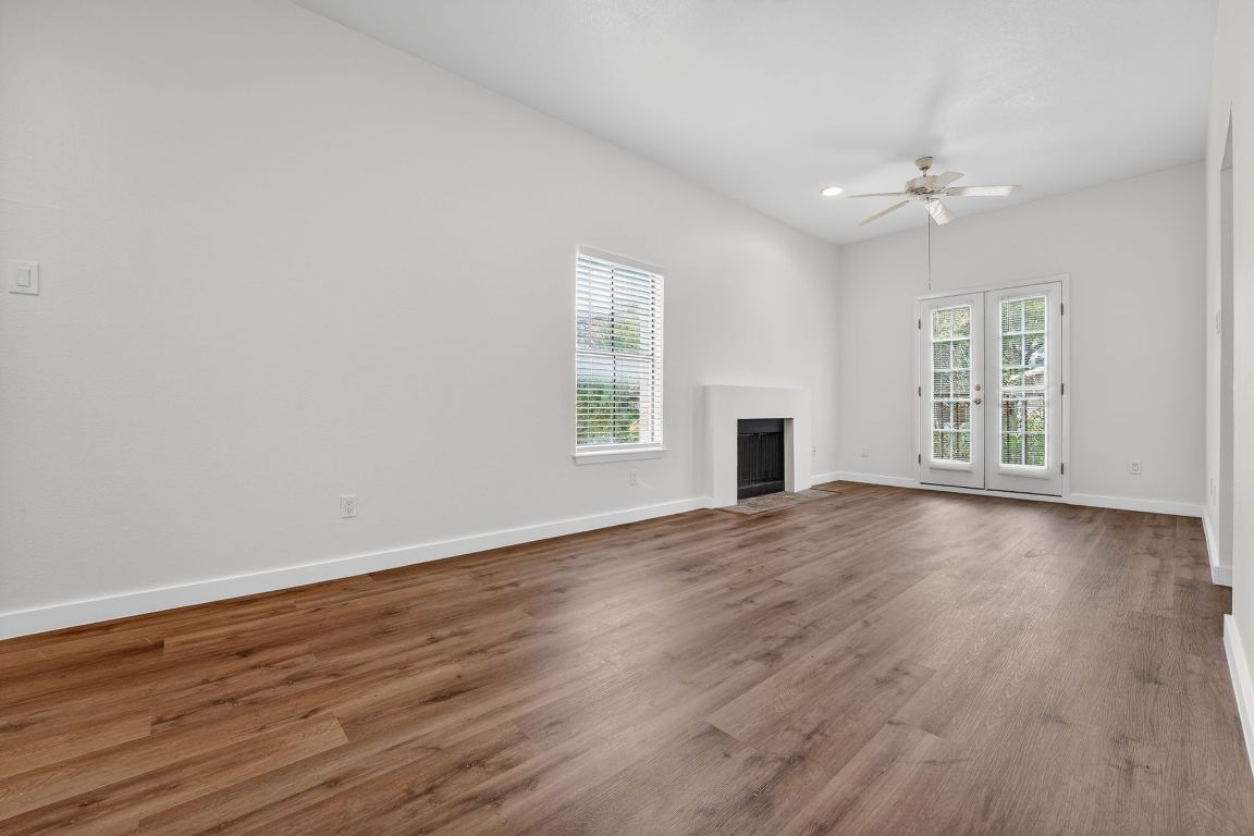 712 Graham Place, Unit 201 Austin, TX 78705 - Photo 12 of 36 an empty room with wooden floor and windows