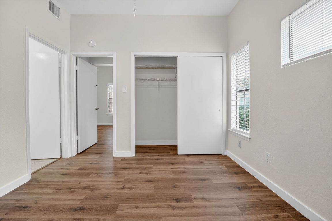712 Graham Place, Unit 201 Austin, TX 78705 - Photo 26 of 36 a view of an empty room with wooden floor and a window
