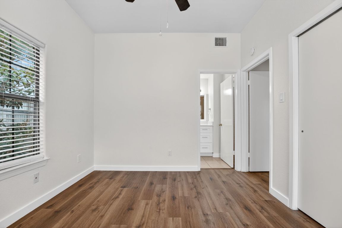712 Graham Place, Unit 201 Austin, TX 78705 - Photo 27 of 36 a view of an empty room with wooden floor and a window