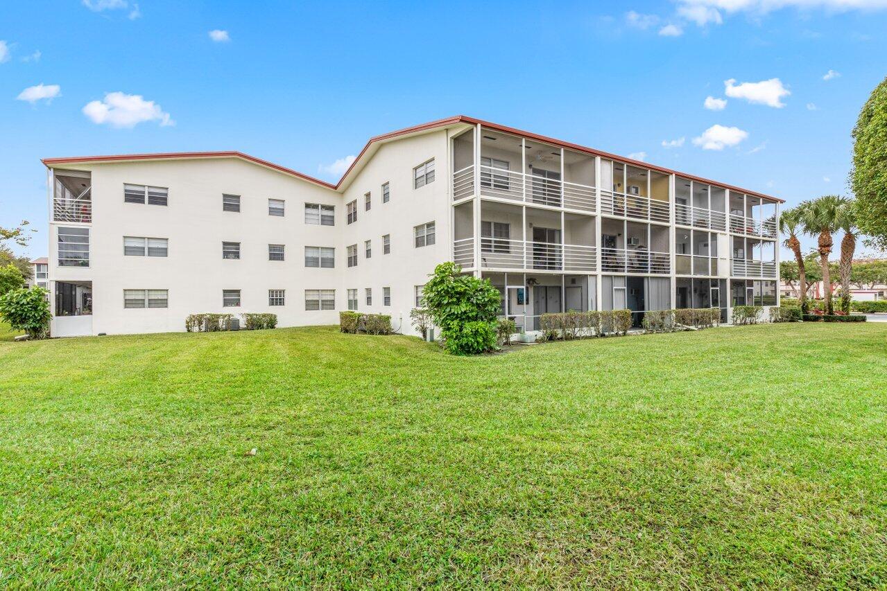 228 Brighton F Boca Raton, FL 33434 - Photo 16 of 24 a front view of a building with garden