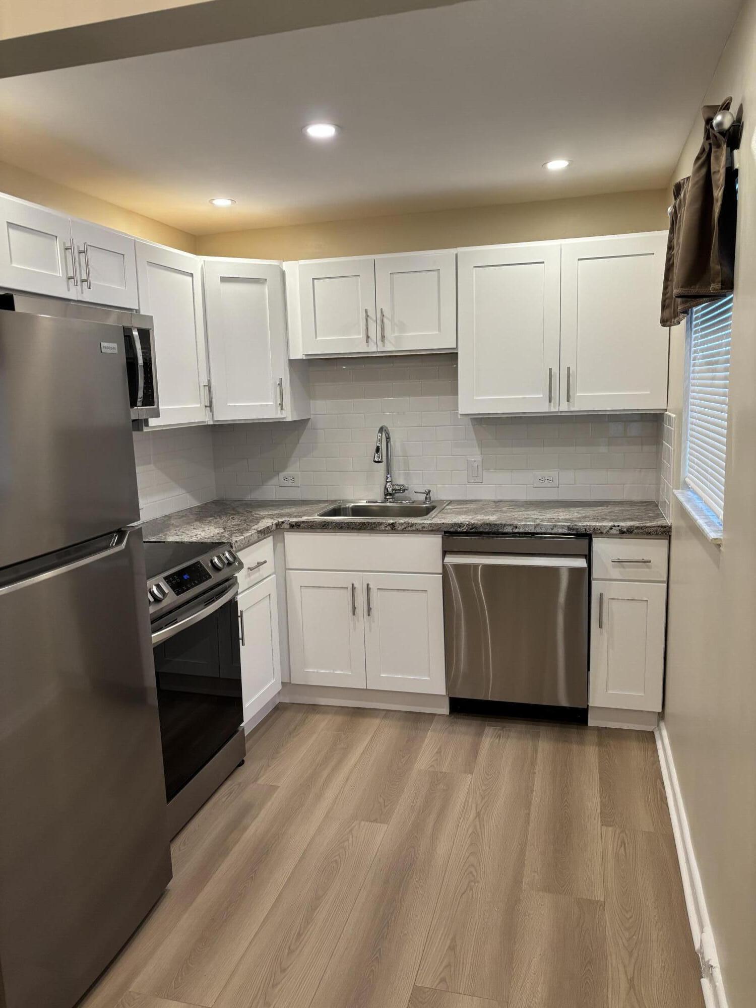 228 Brighton F Boca Raton, FL 33434 - Photo 2 of 24 a kitchen with a sink a stove and refrigerator