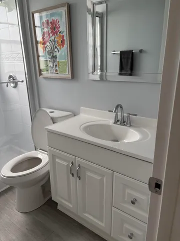 a bathroom with a toilet sink and mirror