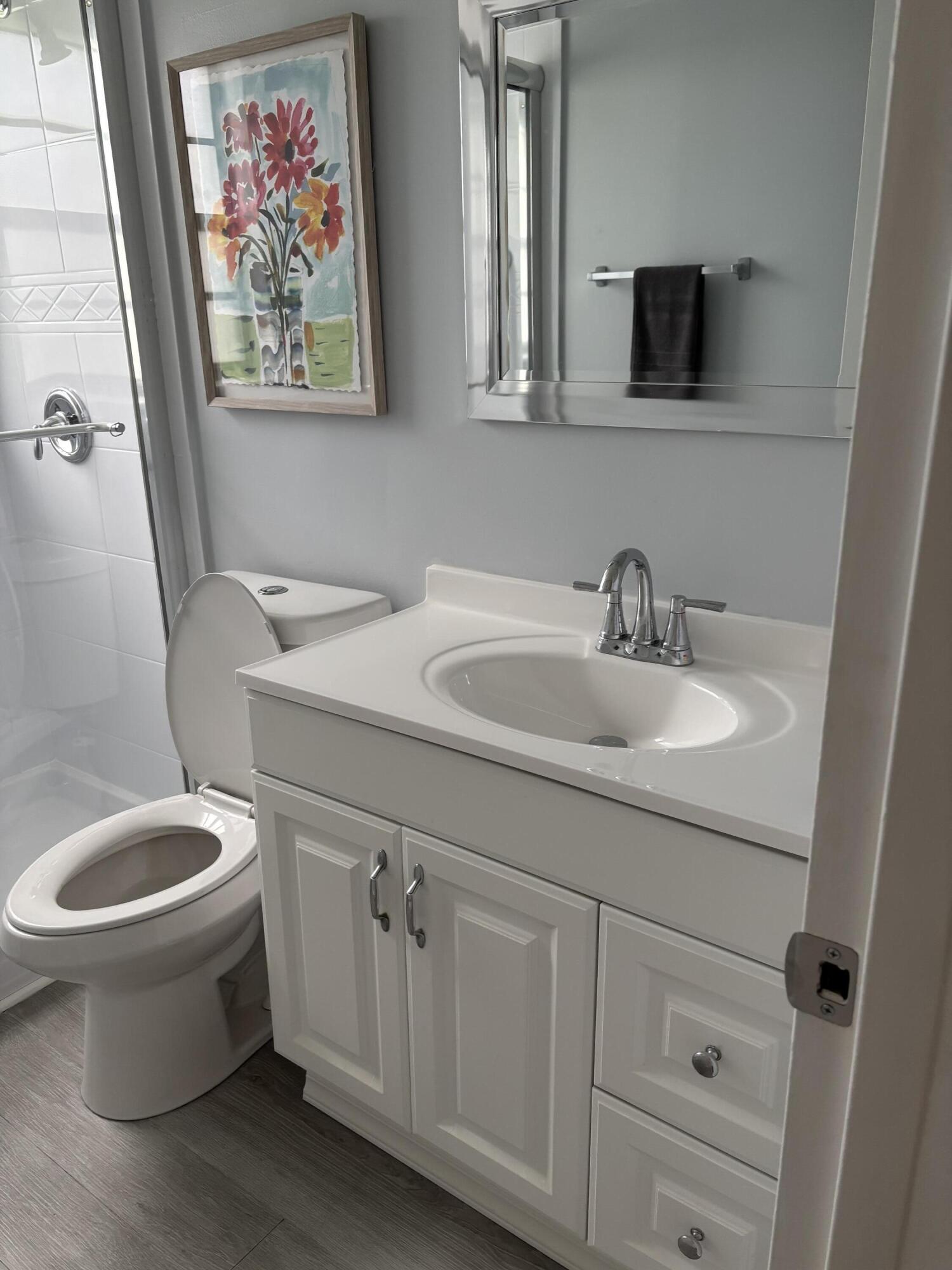 228 Brighton F Boca Raton, FL 33434 - Photo 7 of 24 a bathroom with a toilet sink and mirror