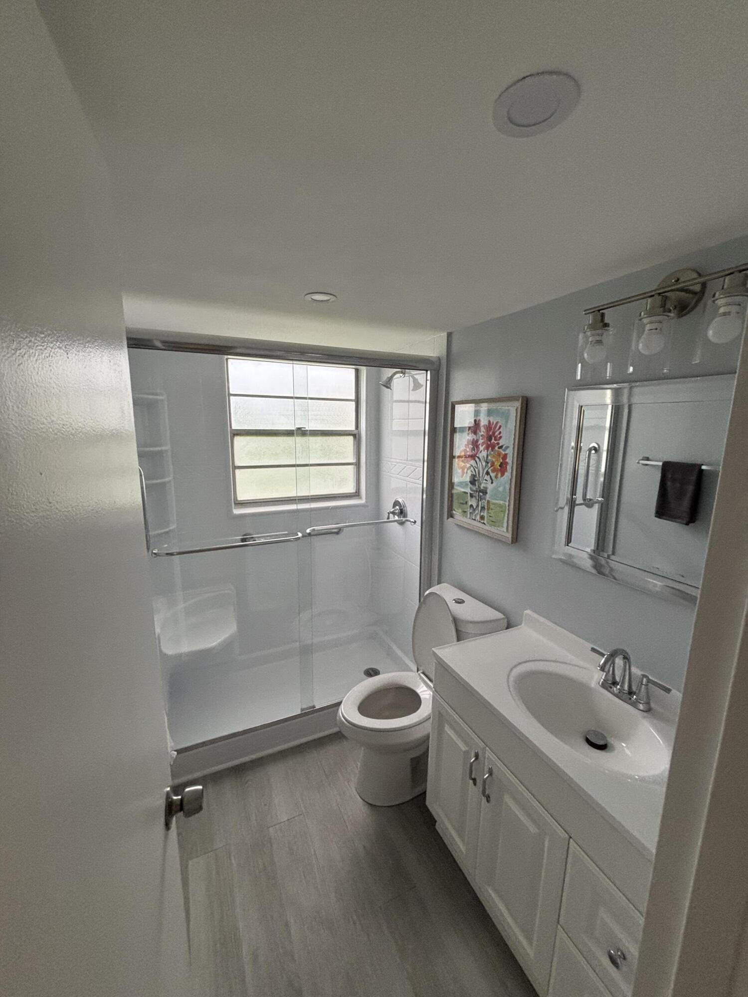 228 Brighton F Boca Raton, FL 33434 - Photo 8 of 24 a bathroom with a double vanity sink toilet mirror and bathtub