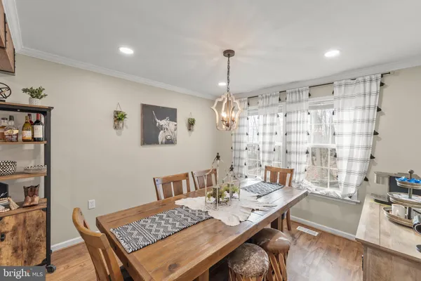 a living room with furniture a dining table and a chandelier
