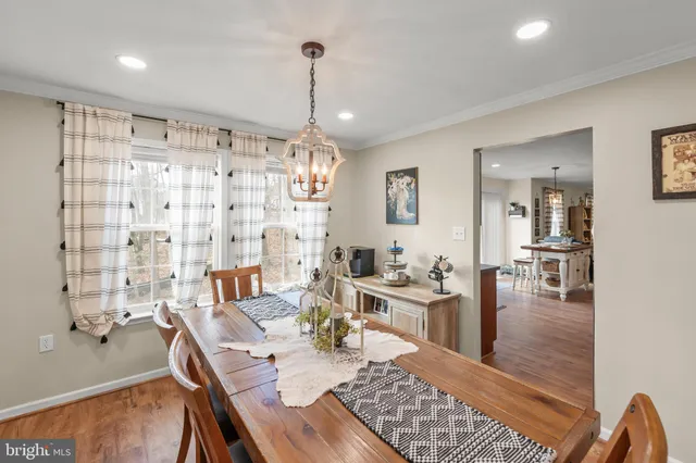 a kitchen with stainless steel appliances granite countertop a stove a sink dishwasher a refrigerator and wooden cabinets with wooden floor