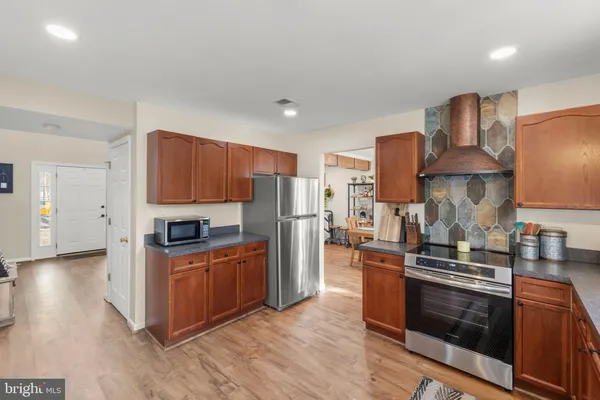 a kitchen with stainless steel appliances granite countertop a refrigerator and a stove top oven