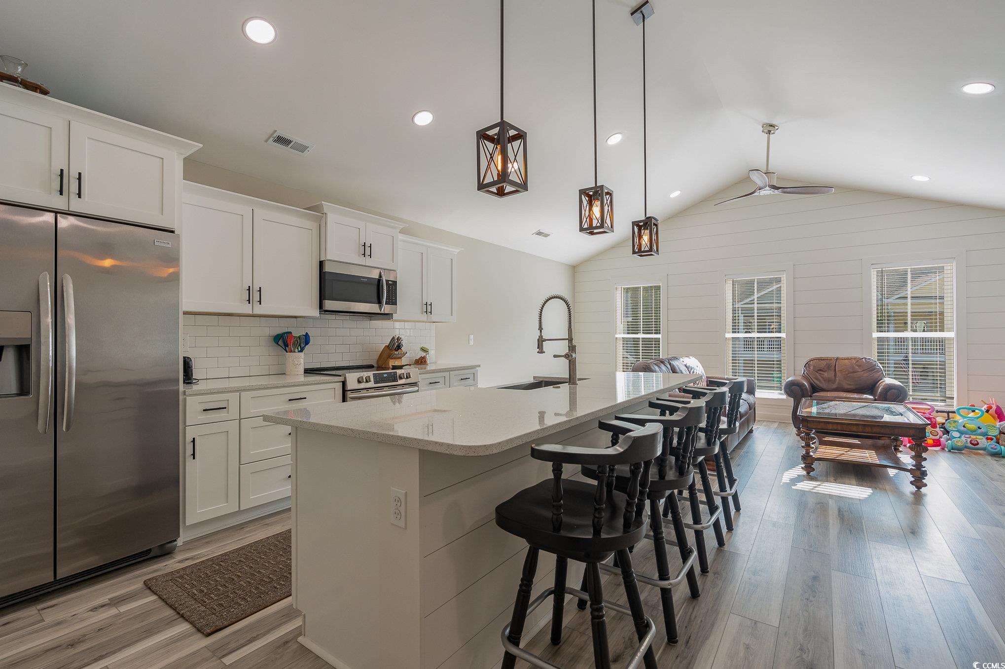 208 Kings Crossing Loop Murrells Inlet, SC 29576 - Photo 8 of 28 Kitchen featuring an island with sink, light hardw