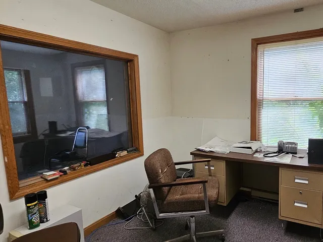 a view of a workspace with furniture and a window