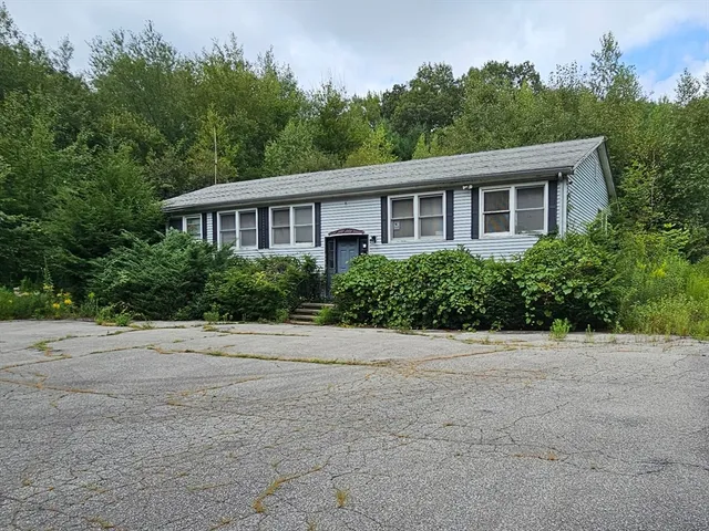 a front view of a house with a yard and trees