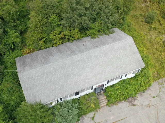 an aerial view of a house with a yard and trees