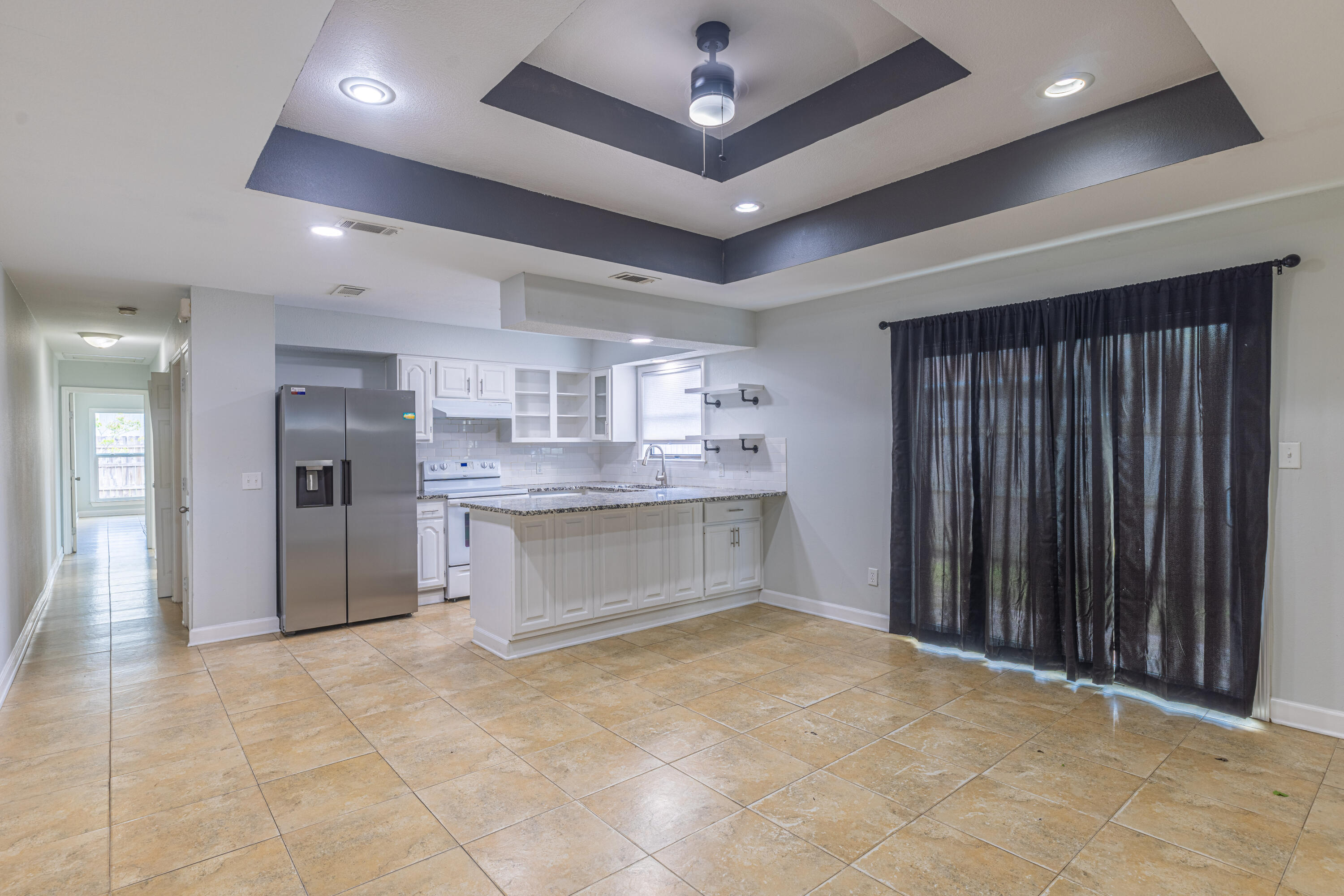 a large kitchen with a large counter top stainless steel appliances and cabinets
