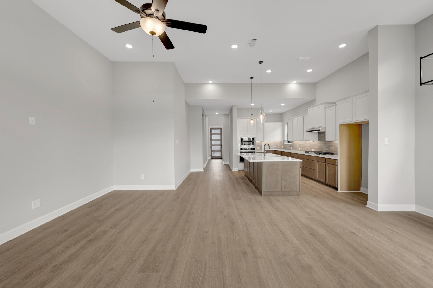 5407 Mango Blfs Street Manvel, TX 77578 - Photo 28 of 50 a view of kitchen with kitchen island white cabinetry refrigerator and microwave