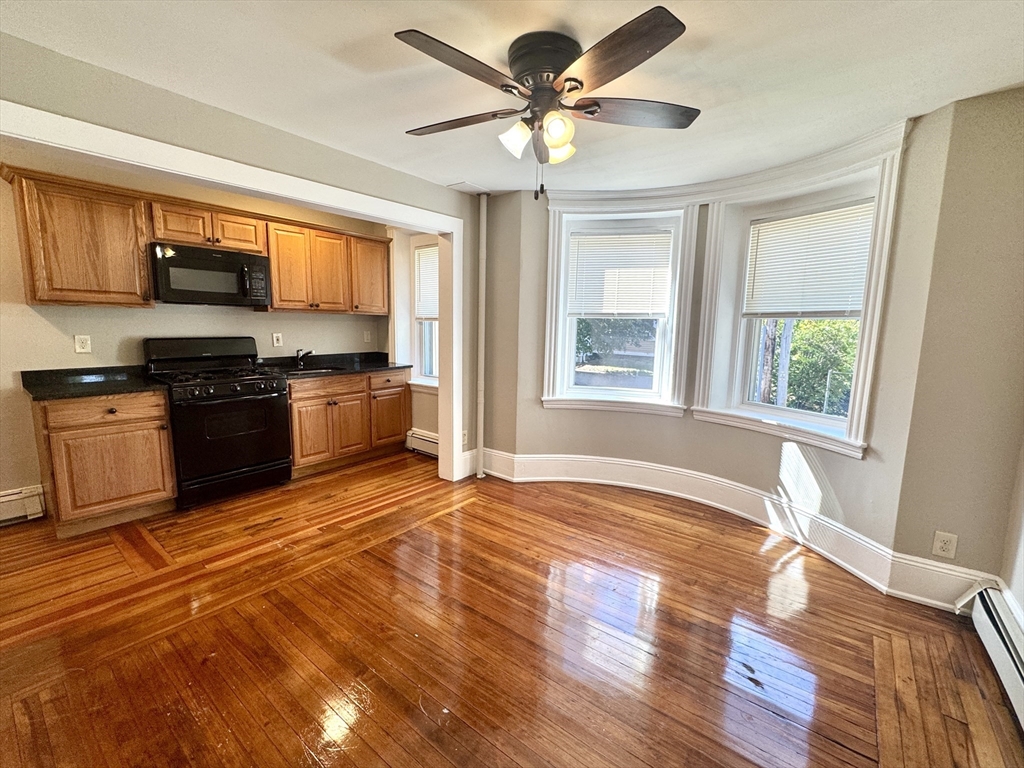 124 Green Street, Unit 201 Lynn, MA 01902 - Photo 1 of 5 a view of a kitchen with a stove cabinets and wooden floor