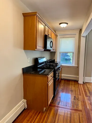 a kitchen with stainless steel appliances a stove and wooden floor
