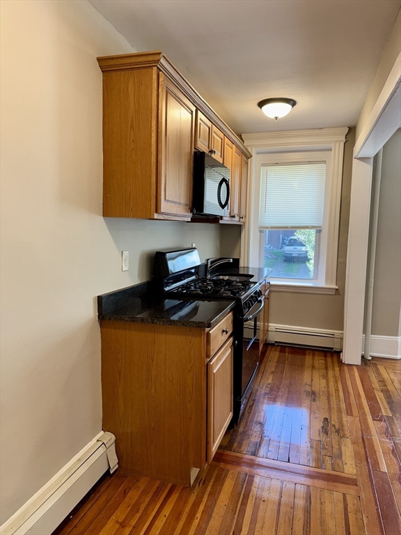 124 Green Street, Unit 201 Lynn, MA 01902 - Photo 3 of 5 a kitchen with stainless steel appliances a stove and wooden floor