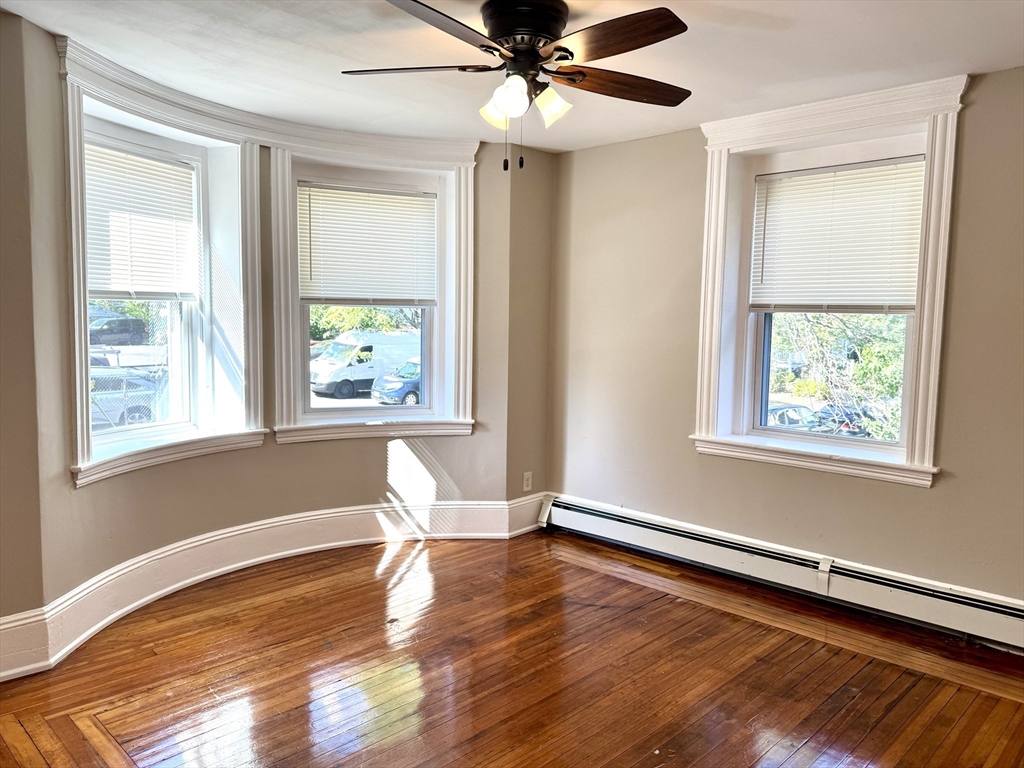 124 Green Street, Unit 201 Lynn, MA 01902 - Photo 4 of 5 a view of an empty room with wooden floor and a window