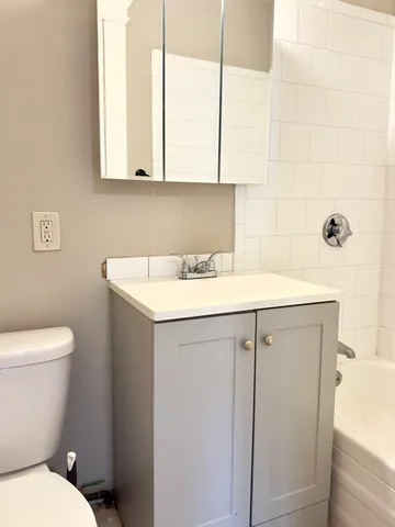 a bathroom with a sink a toilet and a mirror
