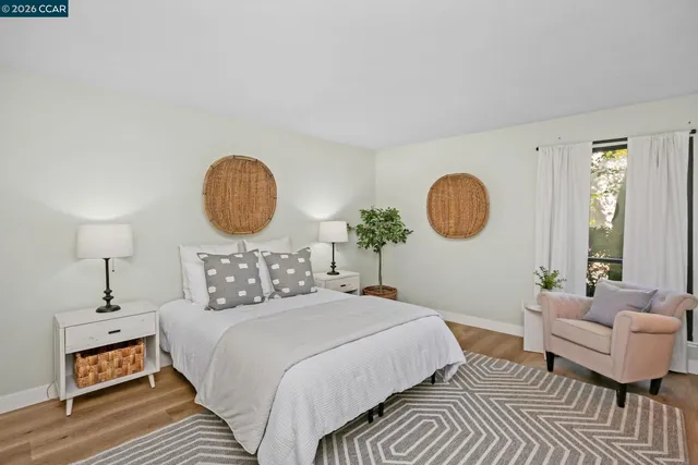 a bedroom with a bed mirror and window
